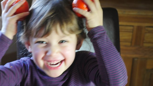 enfant jouant avec des cl&eacute;mentines