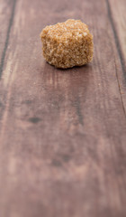 Brown sugarcane sugar cube over wooden background