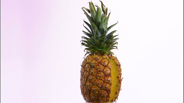 Pineapple rotating on a white screen.