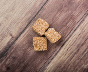 Brown sugarcane sugar cube over wooden background