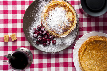 Pancakes with cherries and sugar powder