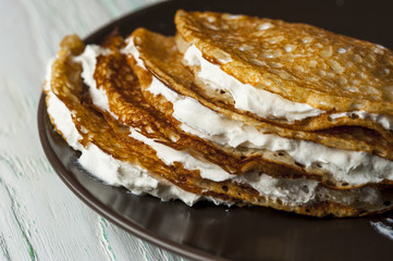 Pancakes with whipped cream on brown plate