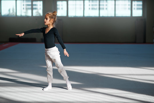 Girl practicing rhythmic gymnastics in  gym