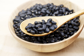 Wooden bowl full of dry black beans