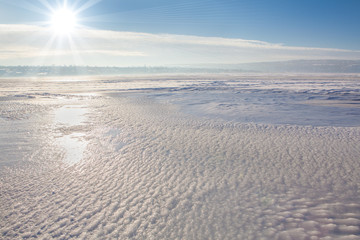 Fototapeta na wymiar cold sun over frozen lake