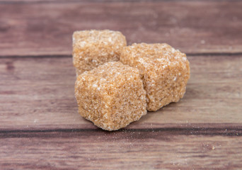 Brown sugarcane sugar cube over wooden background