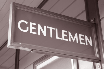 Green Gentleman Toilet Sign against Yellow Background