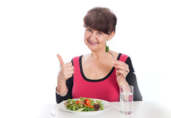 Elderly good looking woman eating green salad. Healthy life style concept