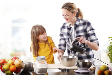 Happy mother and cutie daughter cooking