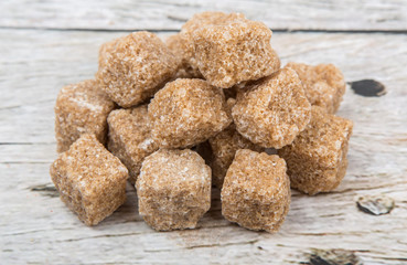 Brown sugarcane sugar cube over wooden background