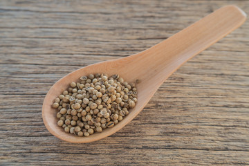 Coriander seeds,Wooden spoon,Wooden floor.