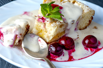 Piece of pineapple pie and cherries on white plate