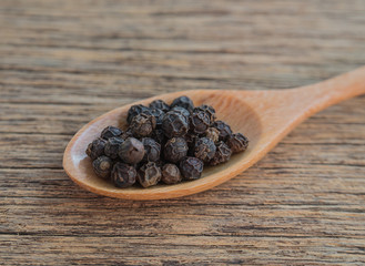 Pepper,Black pepper,Wooden spoon,Wooden floor.