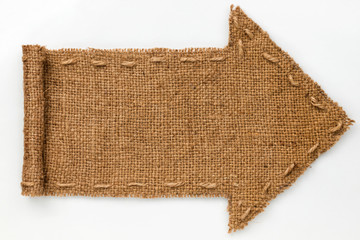 Arrow of burlap with curled edges lies on a white  background,
