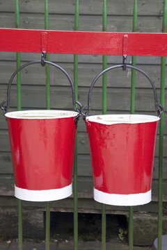 Two Red Buckets against Wall Background