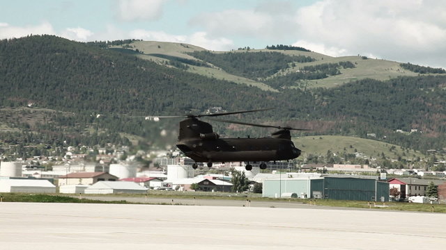 CH-47 Chinook Helicopter hovering above an airfield.