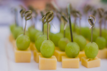 Beautifully decorated banquet catering prepared table with different food snacks and appetizers with sandwich, caviar, fresh fruits on corporate christmas birthday party event or wedding celebration 