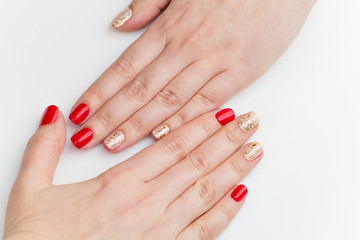 Woman hands with red and gold manicure