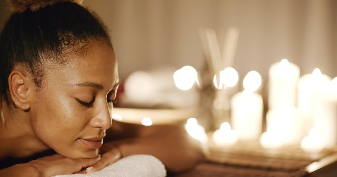 Young african-american woman relaxing on a massage bench.