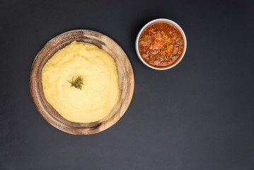 A view from the top of a traditional Polenta with bolognese (ragu) soup on a blackboard surface.