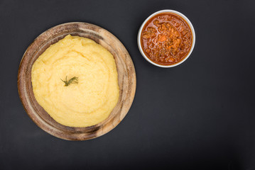 A view from the top of a traditional Polenta with bolognese (ragu) soup on a blackboard surface.