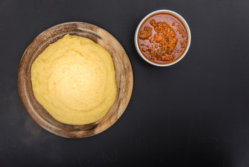 A view from the top of a traditional Polenta with bolognese (ragu) soup on a blackboard surface.