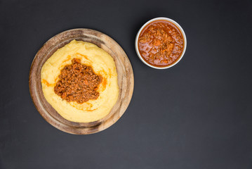 A view from the top of a traditional Polenta with bolognese (ragu) soup on a blackboard surface.