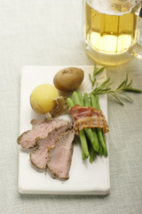 roasted lamb with beans in bacon and potatoes