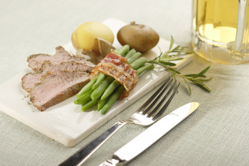 roasted lamb with beans in bacon and potatoes