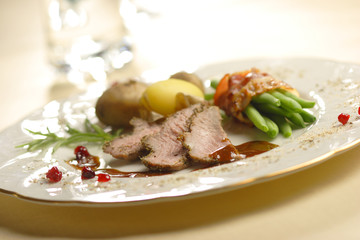 roasted lamb with beans in bacon and potatoes