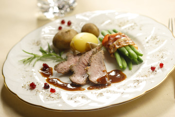 roasted lamb with beans in bacon and potatoes