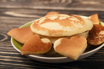 Fototapeta na wymiar heart-shaped pancakes on wooden table