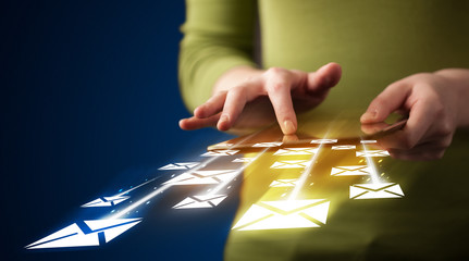 Hand holding tablet and sending email icons
