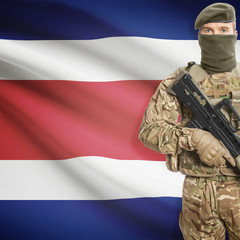 Fototapeta premium Soldier with machine gun and flag on background - Costa Rica