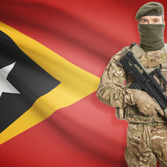 Soldier with machine gun and flag on background - East Timor