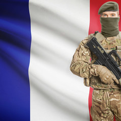 Soldier with machine gun and flag on background - France