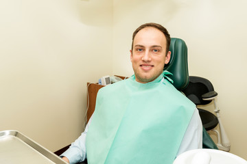 Smiling patient sitting on the dental chair