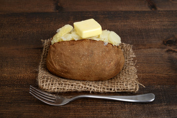 baked potato with butter and fork