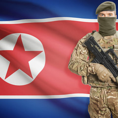 Soldier with machine gun and flag on background - North Korea