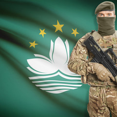 Fototapeta premium Soldier with machine gun and flag on background - Macau