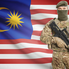 Soldier with machine gun and flag on background - Malaysia
