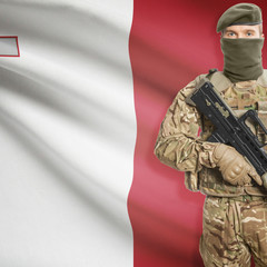 Soldier with machine gun and flag on background - Malta