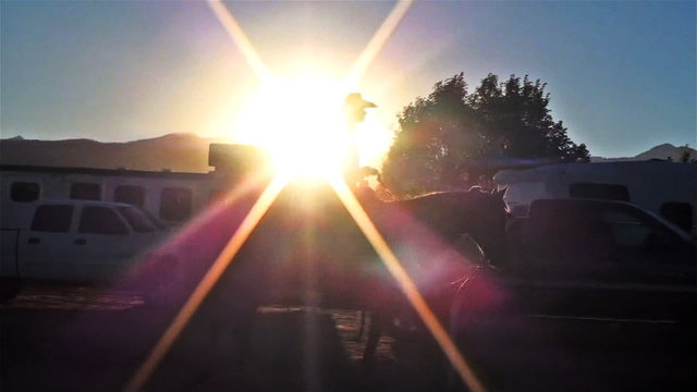 Lens flare shot of a rodeo rider on his horse in Utah
