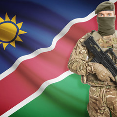Fototapeta premium Soldier with machine gun and flag on background - Namibia