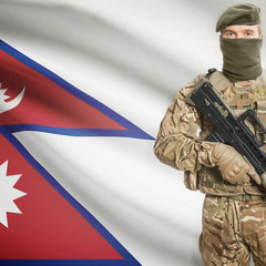 Fototapeta premium Soldier with machine gun and flag on background - Nepal
