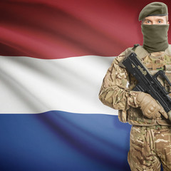Fototapeta premium Soldier with machine gun and flag on background - Netherlands