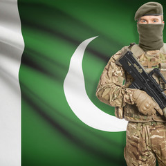 Fototapeta premium Soldier with machine gun and flag on background - Pakistan