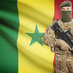 Fototapeta premium Soldier with machine gun and flag on background - Senegal
