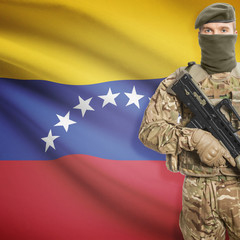 Fototapeta premium Soldier with machine gun and flag on background - Venezuela