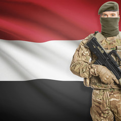 Soldier with machine gun and flag on background - Yemen